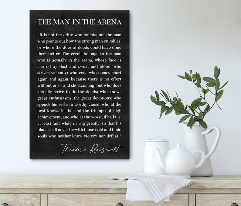 May include: Black and white typography quote on a dark gray background. The quote is by Theodore Roosevelt and reads "It is not the critic who counts: not the man who points out how the strong man stumbles... The credit belongs to the man who is actually in the arena, whose face is marred by dust and sweat and blood: who strives valiantly; who errs, who comes short again and again, because there is no effort without error and shortcoming: but who does actually strive to do the deeds; who knows great enthusiasms, the great devotions: who spends himself in a worthy cause; who at the best knows in the end the triumph of high achievement, and who at the worst, if he fails, at least fails while daring greatly, so that his place shall never be with those cold and timid souls who neither know victory nor defeat."