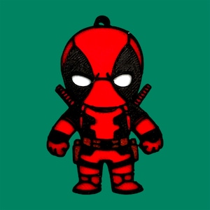 Op de afbeelding: Een rood en zwart 3D-geprint beeldje van Deadpool, een superheldenpersonage. Het beeldje staat met uitgestrekte armen en een zwarte riem.