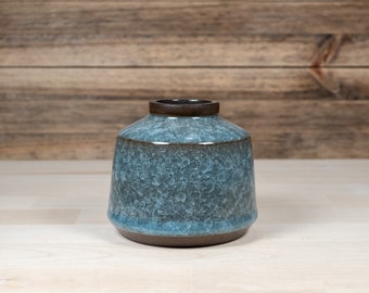 Small vase for spring flowers, made from black stoneware clay and covered with light blue ice-crackle glaze. Height 8 cm / ø 9 cm.