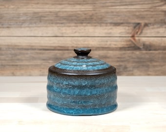 Ceramic storage jar with light blue ice-crackle glaze made from anthracite black stoneware. Height 10 cm. Volume 320ml.
