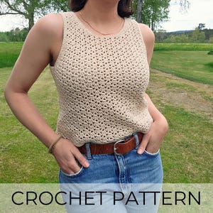 Puede incluir: Un top de ganchillo beige con cuello redondo. El top se combina con vaqueros azules y un cinturón marrón. El texto "CROCHET PATTERN" se muestra en la parte inferior de la imagen. El fondo es un campo de hierba.