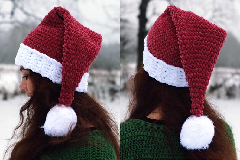 Op de afbeelding: Een rood-witte gebreide kerstmanmuts met een lange, puntige punt en een witte pompon aan het einde. De muts wordt gedragen door een persoon met lang bruin haar.