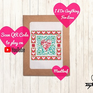 May include: A brown card with a white square containing a red heart QR code surrounded by a border of red, white, and green hearts. The text "Scan QR Code to play on YouTube" is in a pink heart shape on the left side of the card. The text "I'd Do Anything For Love" is in a pink heart shape on the top right of the card. The text "Meatloaf" is in a pink heart shape on the bottom right of the card.