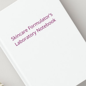 Puede incluir: Cuaderno blanco con el título "Skincare Formulator's Laboratory Notebook" impreso en morado.