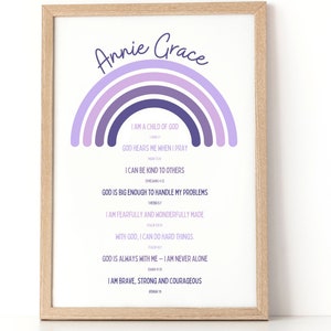 Puede incluir: Un diseño de arte de pared imprimible con un arcoíris en colores púrpura y azul. El diseño incluye el nombre "Annie Grace" y citas inspiradoras sobre la fe y la fuerza.