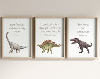 May include: Three framed prints with watercolor illustrations of dinosaurs and inspirational quotes. The first print features a Brachiosaurus with the quote "I am fearfully and wonderfully made." from Psalm 139:14. The second print features a Stegosaurus with the quote "I can do all things through Christ who gives me strength." from Philippians 4:13. The third print features a Tyrannosaurus Rex with the quote "Be strong and courageous." from Joshua 1:9.