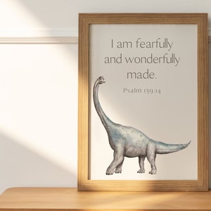 May include: A framed print with a watercolor illustration of a gray dinosaur with a long neck. The print has the text "I am fearfully and wonderfully made. Psalm 139:14"
