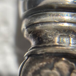 May include: Close-up of a silver object with a hallmark that reads "15E".