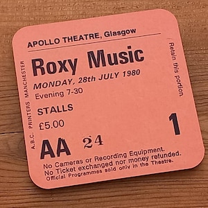 May include: A pink Roxy Music concert ticket from the Apollo Theatre, Glasgow, for Monday 28th July 1980. The ticket shows the time as "Evening 7-30" and seat details. The ticket also has the text "Retain this portion."