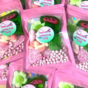 May include: Pink cellophane bags filled with assorted candies, including watermelon slices, flower-shaped gummies, and pink and white sprinkles. Each bag has a circular sticker that reads "Thank you for coming to my Party!"