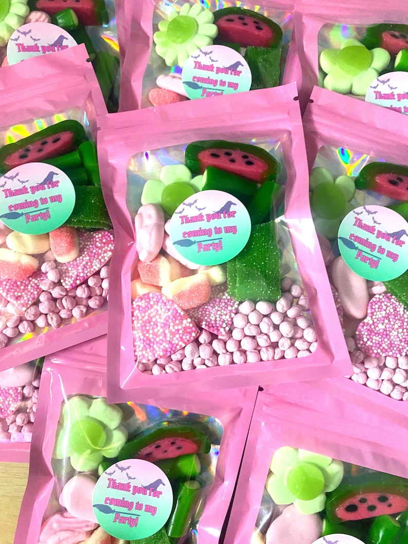 May include: Pink cellophane bags filled with assorted candies, including watermelon slices, flower-shaped gummies, and pink and white sprinkles. Each bag has a circular sticker that reads "Thank you for coming to my Party!"