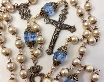 Rosario nupcial: Crucifijo francés de bronce macizo, perlas de nácar, cristales de zafiro, medalla de dos corazones.