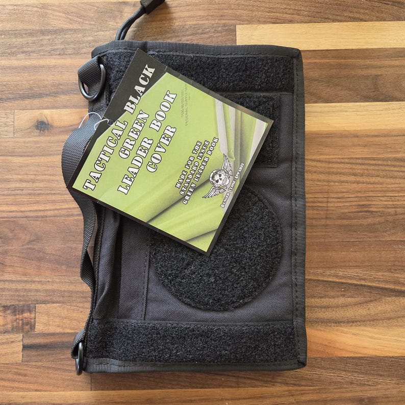 Pu&ograve; includere: Copertina nera tattica per libro leader con tracolla ed etichetta. L'etichetta recita "Tactical Black Green Book Leader Book Cover". La copertina ha una toppa a strappo e una toppa rotonda.