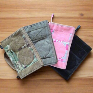 Pu&ograve; includere: Quattro tasche tattiche in vari colori: mimetico, grigio, mimetico rosa e nero. Ogni tasca presenta una toppa circolare, chiusure in velcro e una toppa rettangolare. Le tasche sono progettate per trasportare piccoli oggetti.