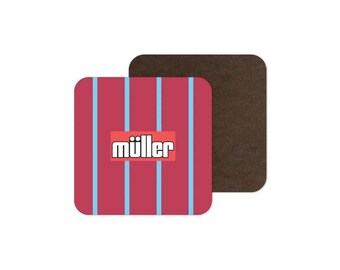 May include: A square drink coaster featuring a dark red background with vertical light blue stripes and a central red rectangular box containing the white text müller in a bold sans-serif font, with a dark brown textured underside visible.