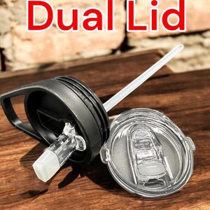 May include: A black and clear dual lid for a tumbler with a straw. The lid has a flip top with a built-in straw hole and a separate lid with a silicone seal.