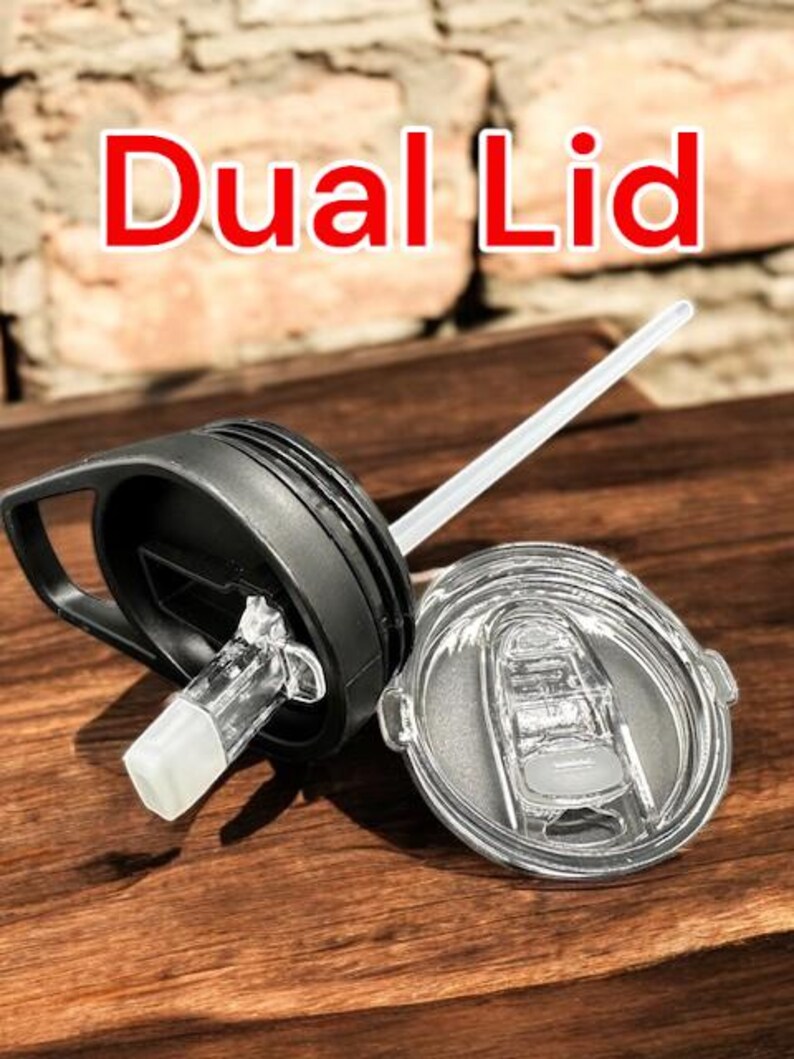May include: A black and clear dual lid for a tumbler with a straw. The lid has a flip top with a built-in straw hole and a separate lid with a silicone seal.