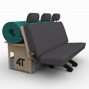 Op de afbeelding: Een grijze driezitsbank met hoofdsteunen, neergeklapt om een platform te creëren. Op het platform ligt een opgerolde turquoise yogamat. Het platform is gemaakt van hout en heeft een opbergvak met een grijze plastic bak. De tekst "4T" en "www.four-teile.de" is op het hout gedrukt.