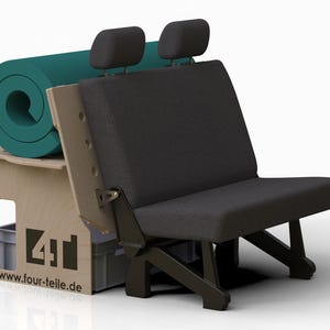 May include: A black upholstered seat with two headrests, a wooden frame, and black legs. A rolled-up teal yoga mat rests on a wooden box with the text "four-teile.de".