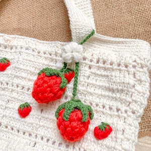 Strawberry Crochet HandBag.
This bag is unique because it has a strawberry pattern attached to the top of this white bag. This bag is also equipped with a strawberry hanger which will certainly beautify this bag.