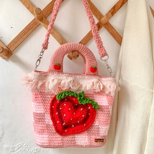 Strawberry Crochet Handbag or Shoulder Bag.
This crochet bag has a pink geometric base combined with a strawberry pattern in the middle of it.  you can choose the style you want.