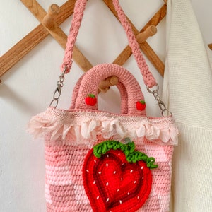 Strawberry Crochet Handbag or Shoulder Bag.
This crochet bag has a pink geometric base combined with a strawberry pattern in the middle of it.  you can choose the style you want.