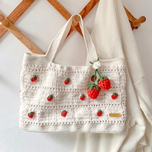 Strawberry Crochet HandBag.
This bag is unique because it has a strawberry pattern attached to the top of this white bag. This bag is also equipped with a strawberry hanger which will certainly beautify this bag.