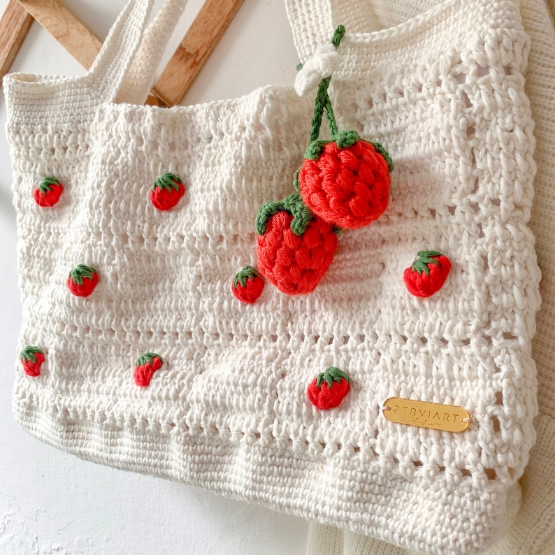 Strawberry Crochet HandBag.
This bag is unique because it has a strawberry pattern attached to the top of this white bag. This bag is also equipped with a strawberry hanger which will certainly beautify this bag.