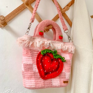 Strawberry Crochet Handbag or Shoulder Bag.
This crochet bag has a pink geometric base combined with a strawberry pattern in the middle of it.  you can choose the style you want.