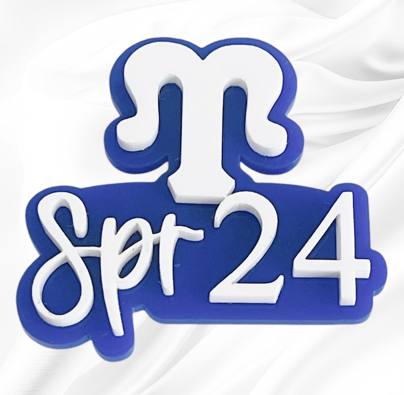 May include: Blue and white plastic sticker with the text "Spr-24" and a white stylized letter "M" above the text.