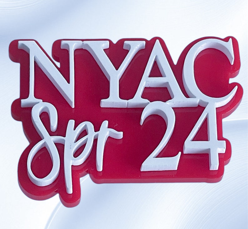 May include: A red and white acrylic sign with the text "NYAC Spr 24" in white lettering.