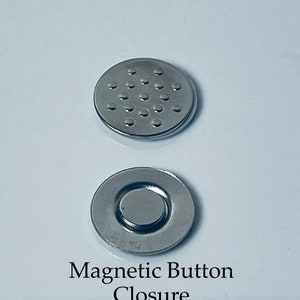 May include: Two silver magnetic button closures. One closure has a flat surface with a pattern of small circles. The other closure has a recessed center with a round magnet.