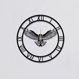 Könnte beinhalten: Schwarze Wanduhr aus Metall mit römischen Ziffern und einem Adlermotiv in der Mitte.