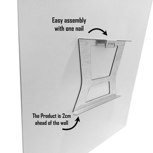 May include: A metal hanging system for a picture frame. The system is designed to be easy to assemble with one nail. The product is 2cm ahead of the wall.