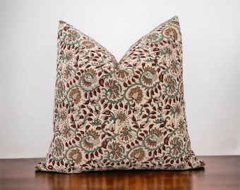 May include: A decorative pillow with a floral pattern in shades of brown, green, and cream. The pillow is made of a soft, textured fabric and has a subtle sheen.