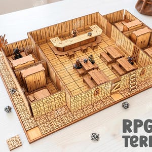 May include: A detailed, laser-cut wooden RPG terrain model, featuring rooms, tables, and a bar. The model includes miniature figures and dice, with the text "RPG Terrain" and "Digital Download" visible. The material width is 3mm.