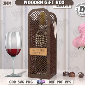 May include: A laser-cut wooden gift box with a geometric design, holding a wine bottle. The box has a label that reads "ENJOY THE MOMENT." A wine glass with red wine and a bouquet of pink roses are also present. The text "WOODEN GIFT BOX" is visible.
