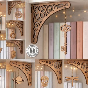 May include: Wooden laser-cut shelf brackets with decorative designs, including a key, a unicorn, a rose, and a moth. The brackets are displayed against a backdrop of books and fairy lights. The text "10 Designs" is visible.