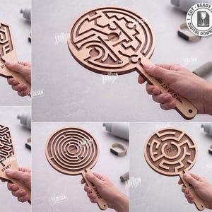 May include: A collection of five wooden handheld maze puzzles with laser-cut paths and a small metal ball. Each puzzle features a handle with the word START and a central area labeled FINISH. The designs include hexagonal and circular shapes.