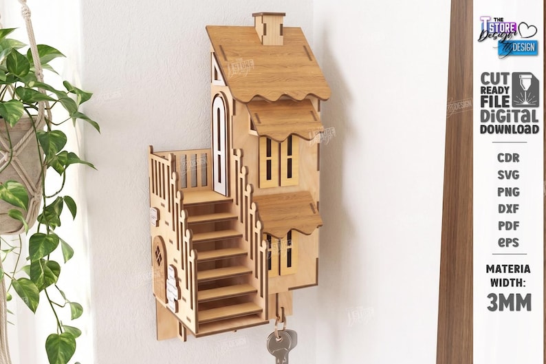 May include: A light brown wooden wall-mounted key holder shaped like a multi-story house with a staircase, balcony, and windows. The design includes text stating CUT READY FILE DIGITAL DOWNLOAD and MATERIA WIDTH: 3MM, with a metal key hanging below.