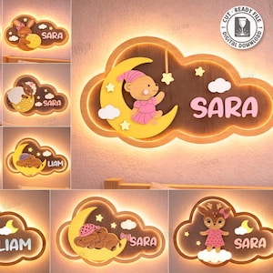 May include: Wooden cloud-shaped night lights with various animal designs, including a bear, bunny, sheep, and deer, each holding a moon. The names "Liam" and "Sara" are displayed on some lights. The image also shows a "Digital Download" graphic.