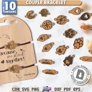 Op de afbeelding: Houten koppelarmbanden met diverse bedelontwerpen, waaronder harten, poten en kompassen. De displaykaart leest "Because we stick together!" en bevat een bijenbedel. Roze hartvormige decoraties zijn ook zichtbaar.
