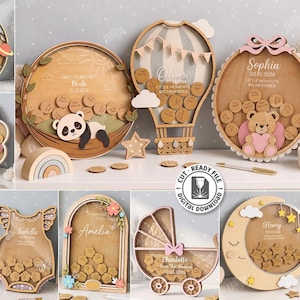 May include: A collection of ten laser-cut wooden shadow box frames in various shapes including a moon, hot air balloon, shell, and baby carriage. Each frame features personalized names, dates, and small wooden tokens for keepsakes.