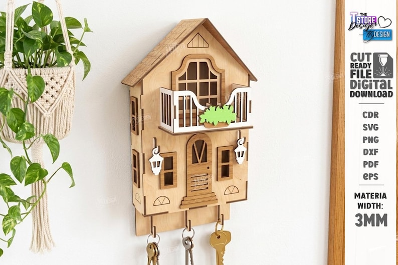 May include: A light-colored wooden wall-mounted key holder shaped like a house with a balcony, a central door, and two white lantern-style accents. The structure features three metal hooks at the bottom holding keys and a 3mm material width label.