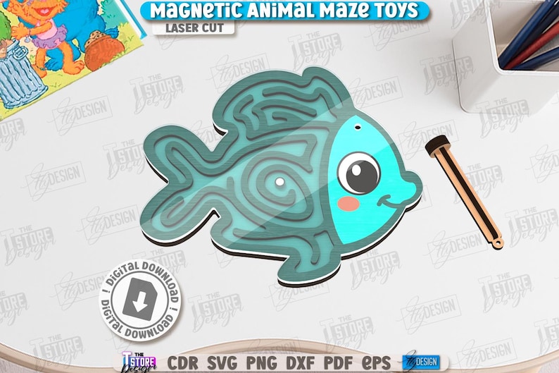 May include: A teal fish-shaped magnetic maze toy with a wooden wand. The maze has a spiral design within the fish's body. The text "MAGNETIC ANIMAL MAZE TOYS" and "LASER CUT" are visible. A digital download icon is also present.