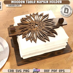 May include: Wooden table napkin holder with a laser-cut sunflower design. The holder is made of dark brown wood and holds a stack of white napkins. The text "WOODEN TABLE NAPKIN HOLDER" is visible.