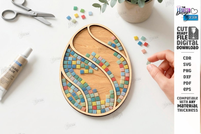 May include: Wooden egg-shaped mosaic craft kit with colorful tiles. The kit includes a wooden base, mosaic tiles in various colors, and mosaic glue. Scissors and a tube of glue are also visible.