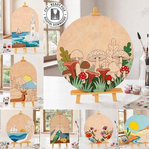 May include: A collection of ten wooden laser cut designs, each displayed on a small easel. The designs feature various nature scenes, including a lighthouse, a forest, a deer, and a mushroom scene. The designs are compatible with any material thickness.
