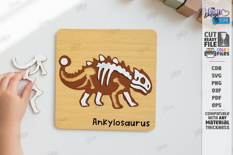 K&ouml;nnte beinhalten: Holzpuzzle mit einem braunen Ankylosaurus-Dinosaurier mit wei&szlig;en Knochen-Details. Das Puzzle befindet sich auf einem hellen Holzmaserungshintergrund. Der Text "Ankylosaurus" steht unten. Eine Hand h&auml;lt Puzzleteile.