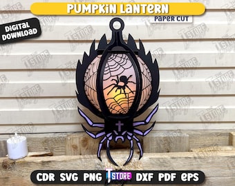 May include: A black paper cut pumpkin lantern with a spider and web design. The lantern has a handle and is decorated with a spider and web design. The text "PUMPKIN LANTERN" and "PAPER CUT" are at the top. The words "DIGITAL DOWNLOAD" are also visible.